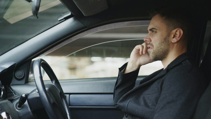 Außendienstler im Anzug telefoniert in seinem Auto